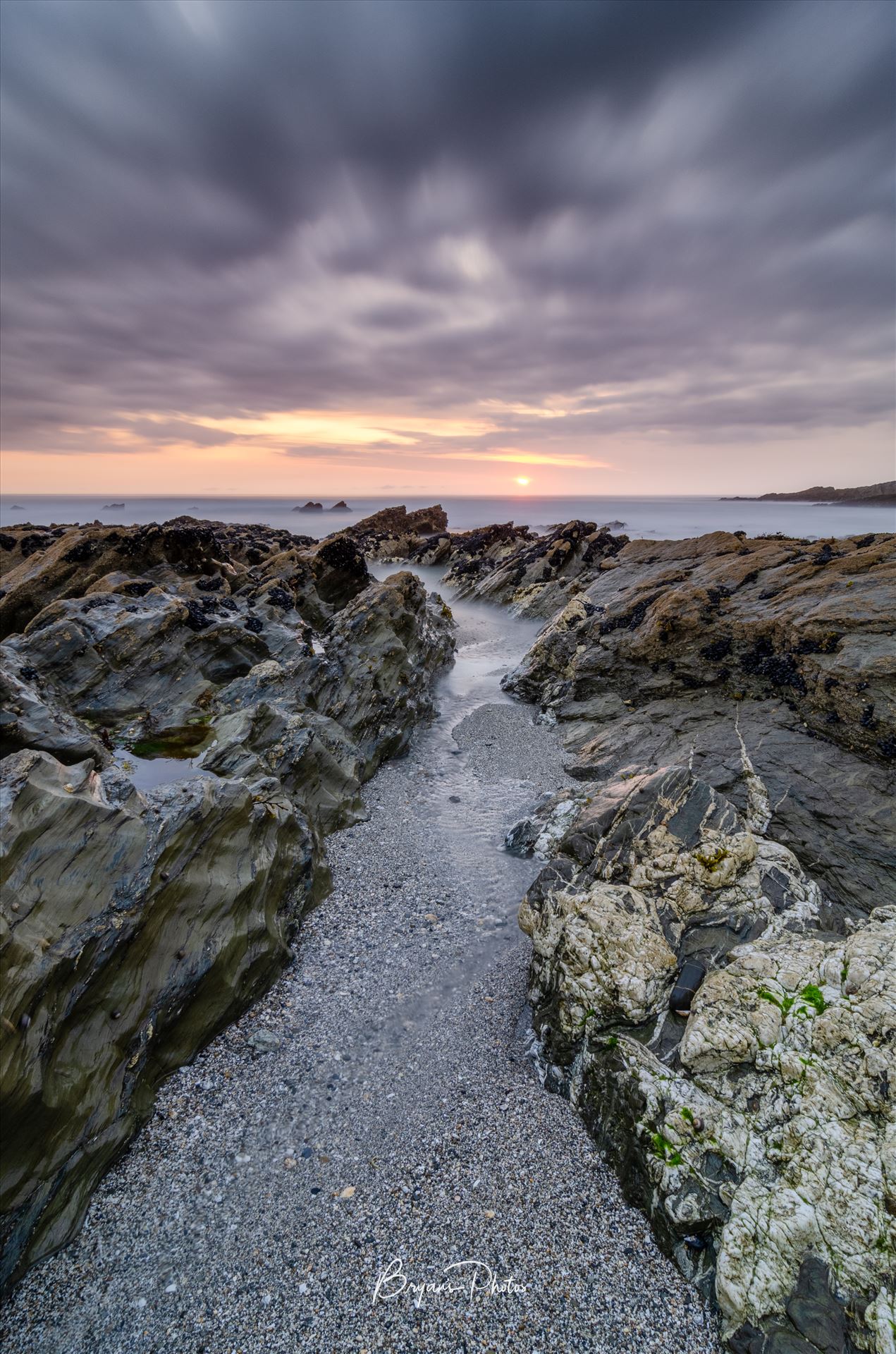 Little Fistral Sunset Portrait - A portrait photograph of the sun setting at Little Fistral Beach in Newquay north Cornwall. by Bryans Photos