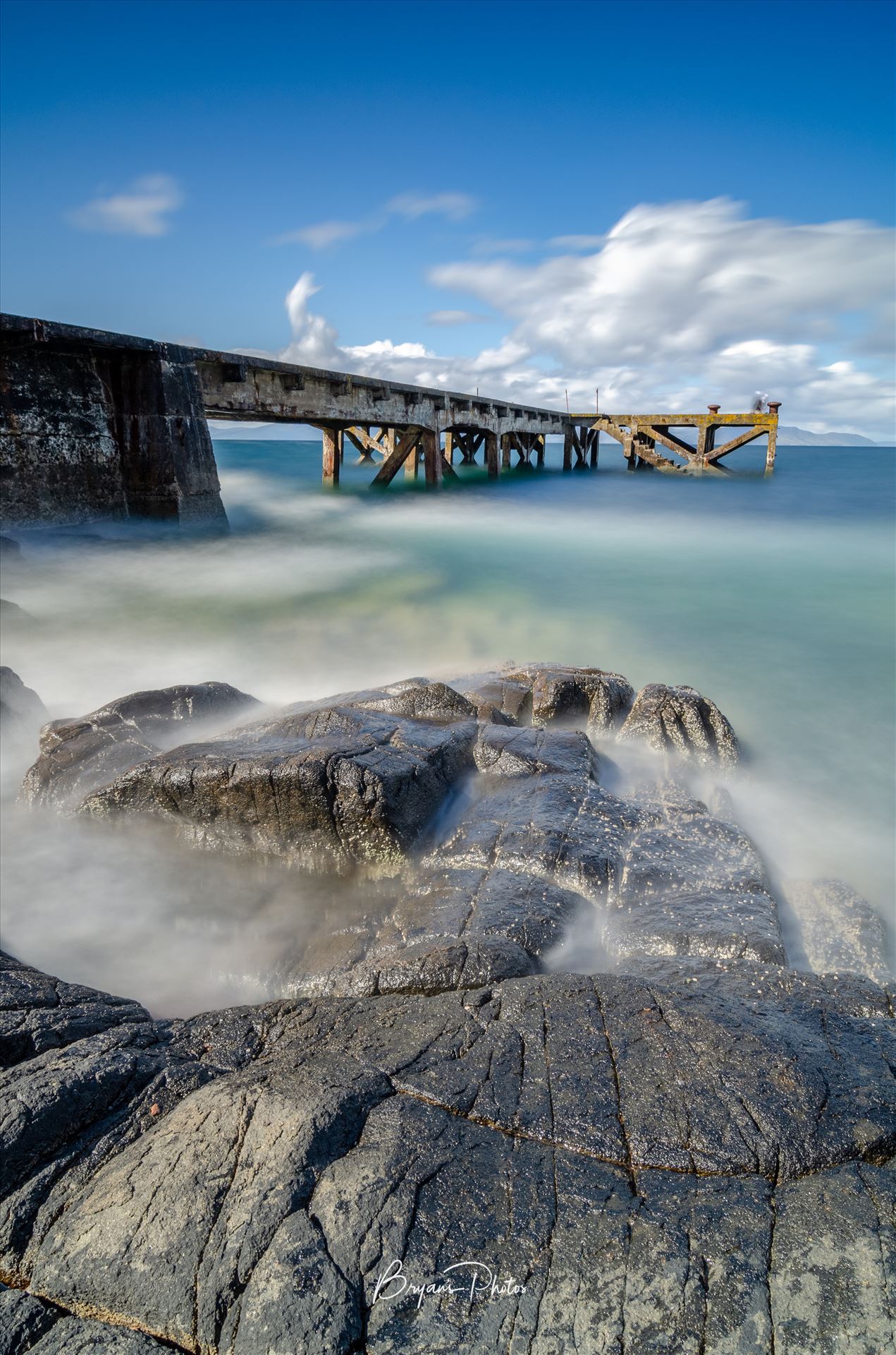 Portencross Portrait - A photograph of the pier at Portenross looking over towards the Isle of Arran. by Bryans Photos