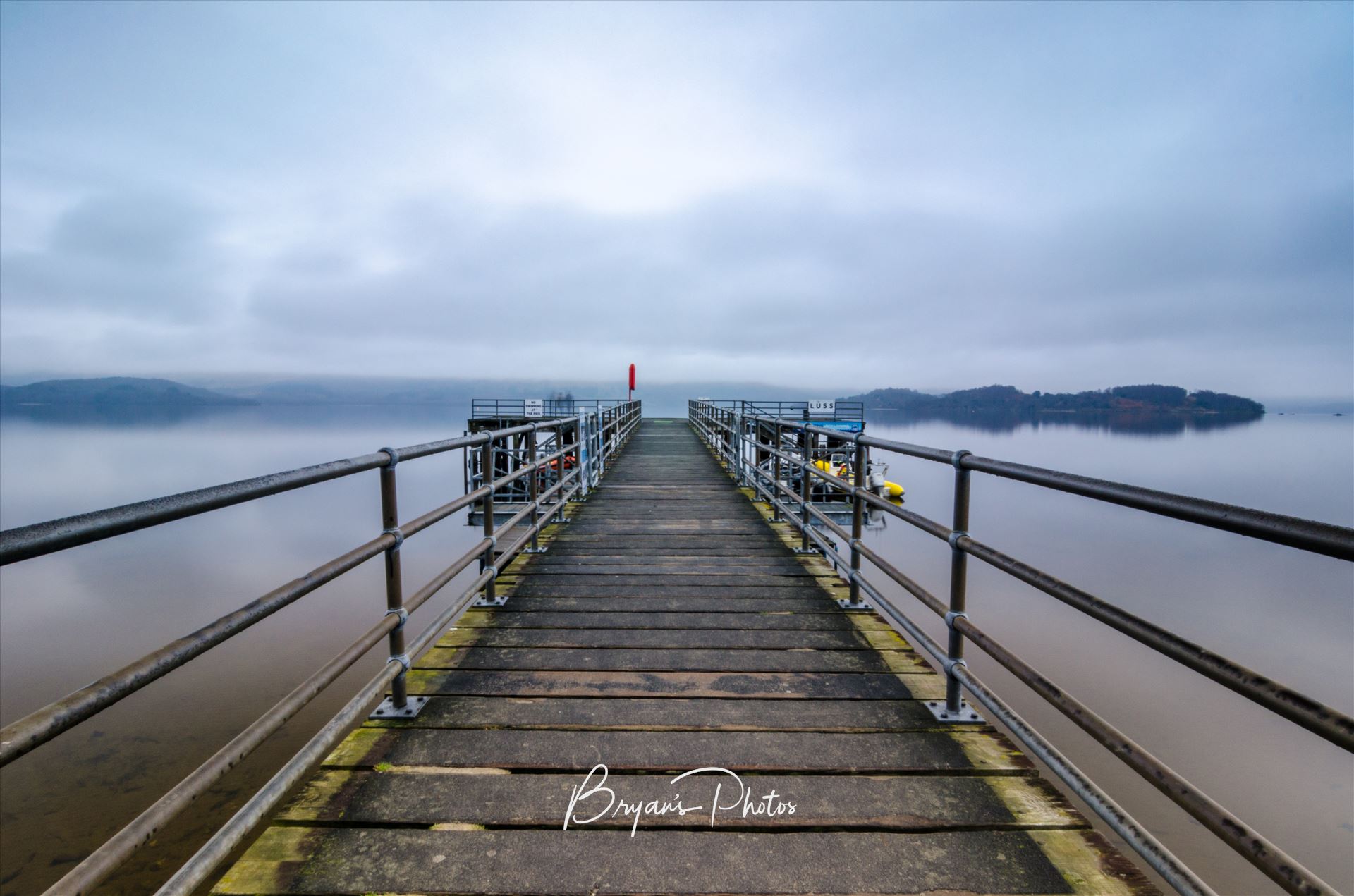 Luss on Loch Lomond - A long exposure photograph of the Pier at Luss on the banks of Loch Lomond. by Bryans Photos