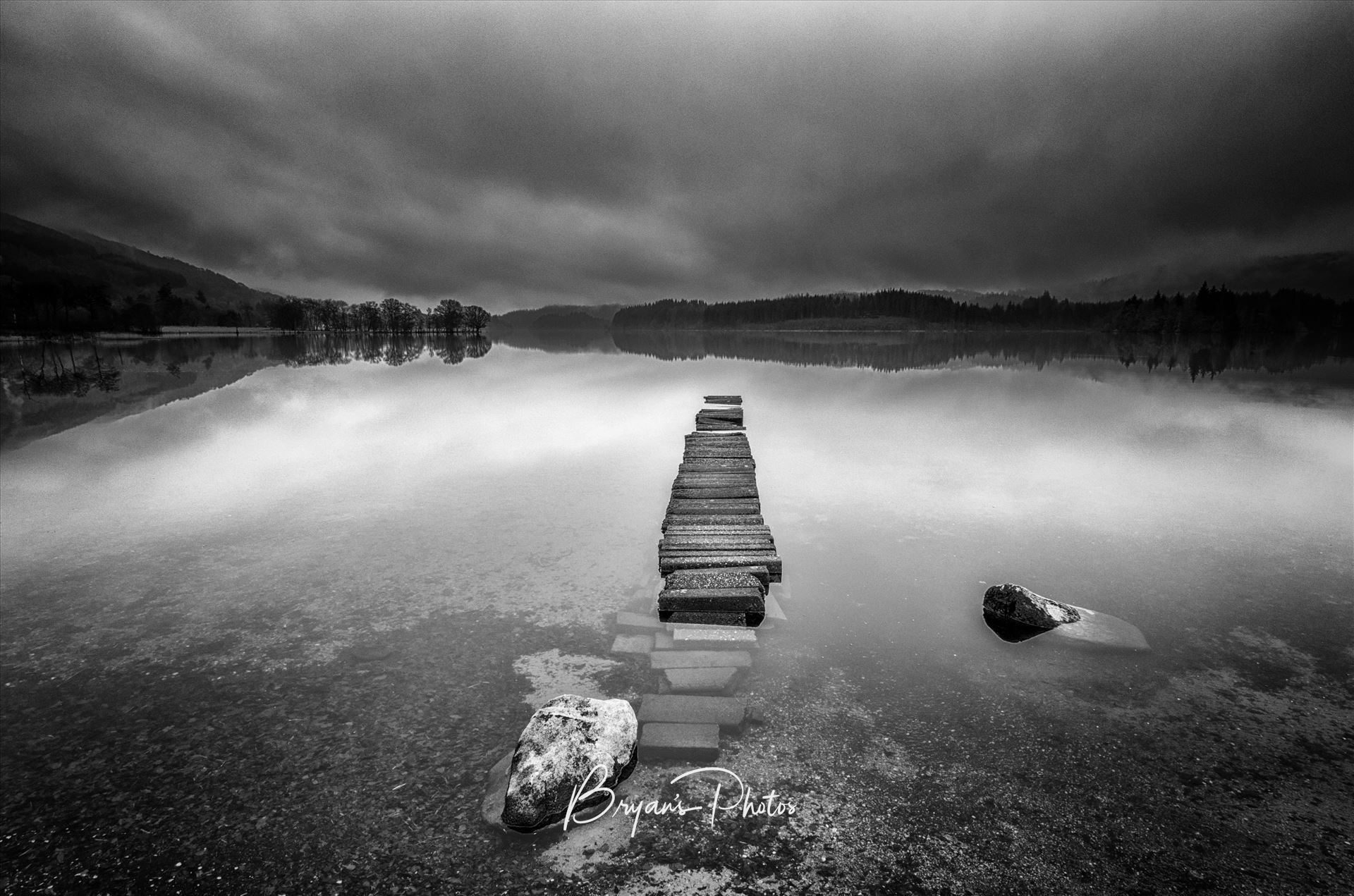 Loch Ard Landscape - A black and white photograph of an old jetty at Loch Ard taken from Kinlochard. by Bryans Photos