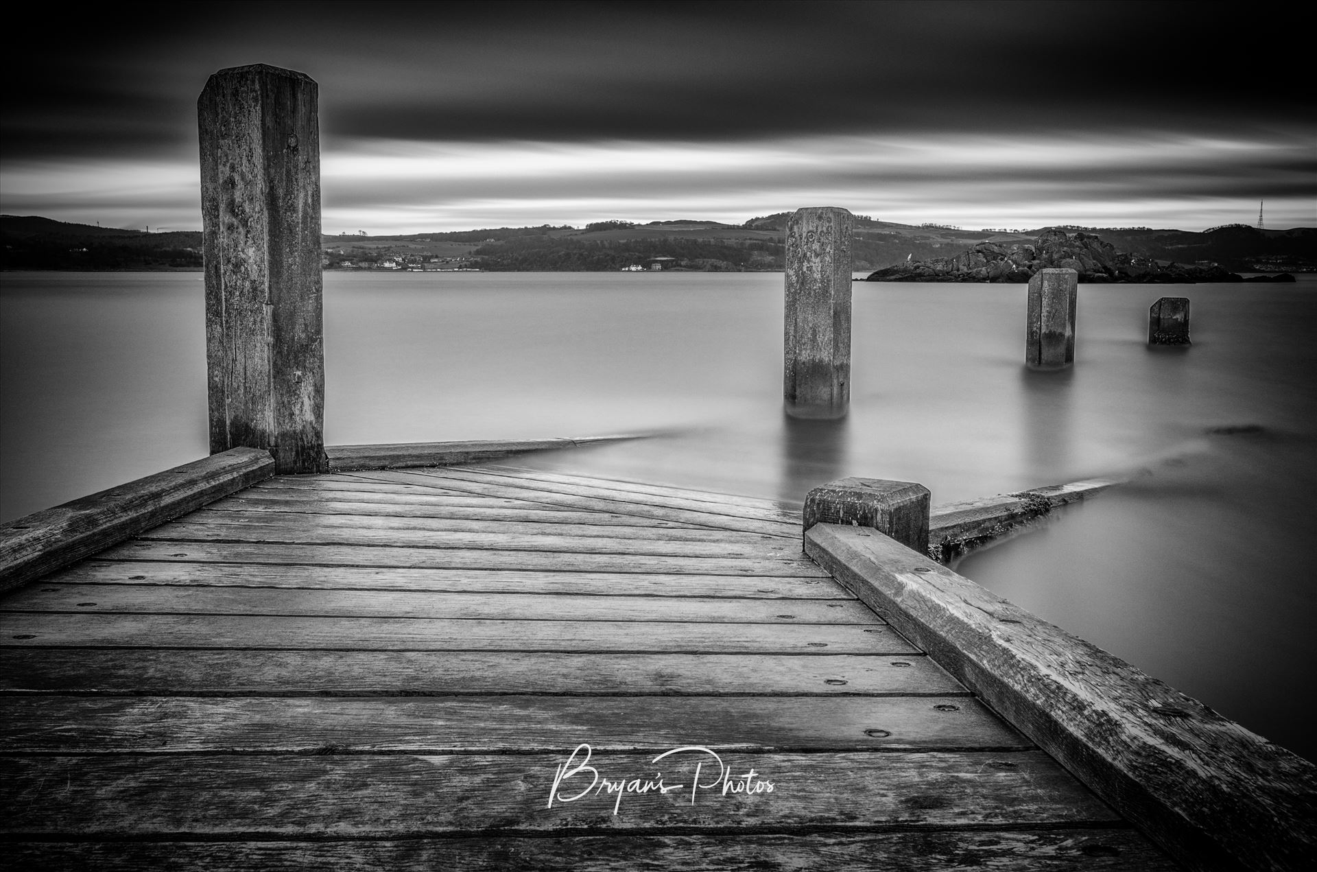 Inchcolm Jetty - A black and white long exposure photograph taken from the jetty at Inchcolm Island looking towards the Fife coast. by Bryans Photos