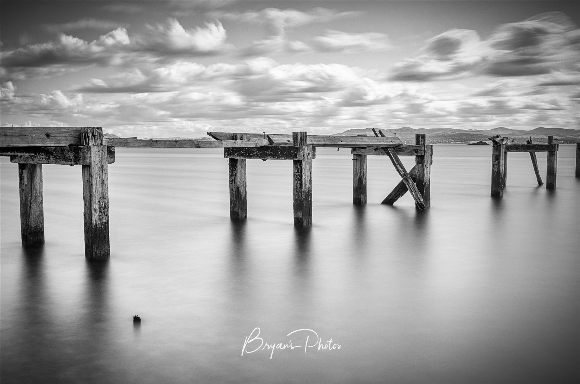 Aberdour - A black and white photograph of the old abandoned pier at Aberdour on the Fife coast. by Bryans Photos