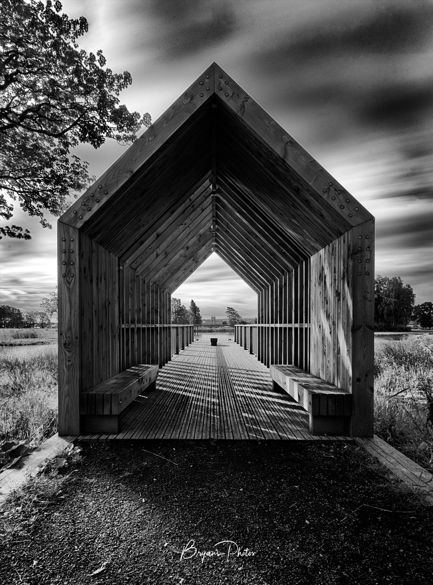 The Boathouse - A black and white photograph of the boathouse at Larbert loch within the grounds of Forth Valley Royal Hospital. by Bryans Photos