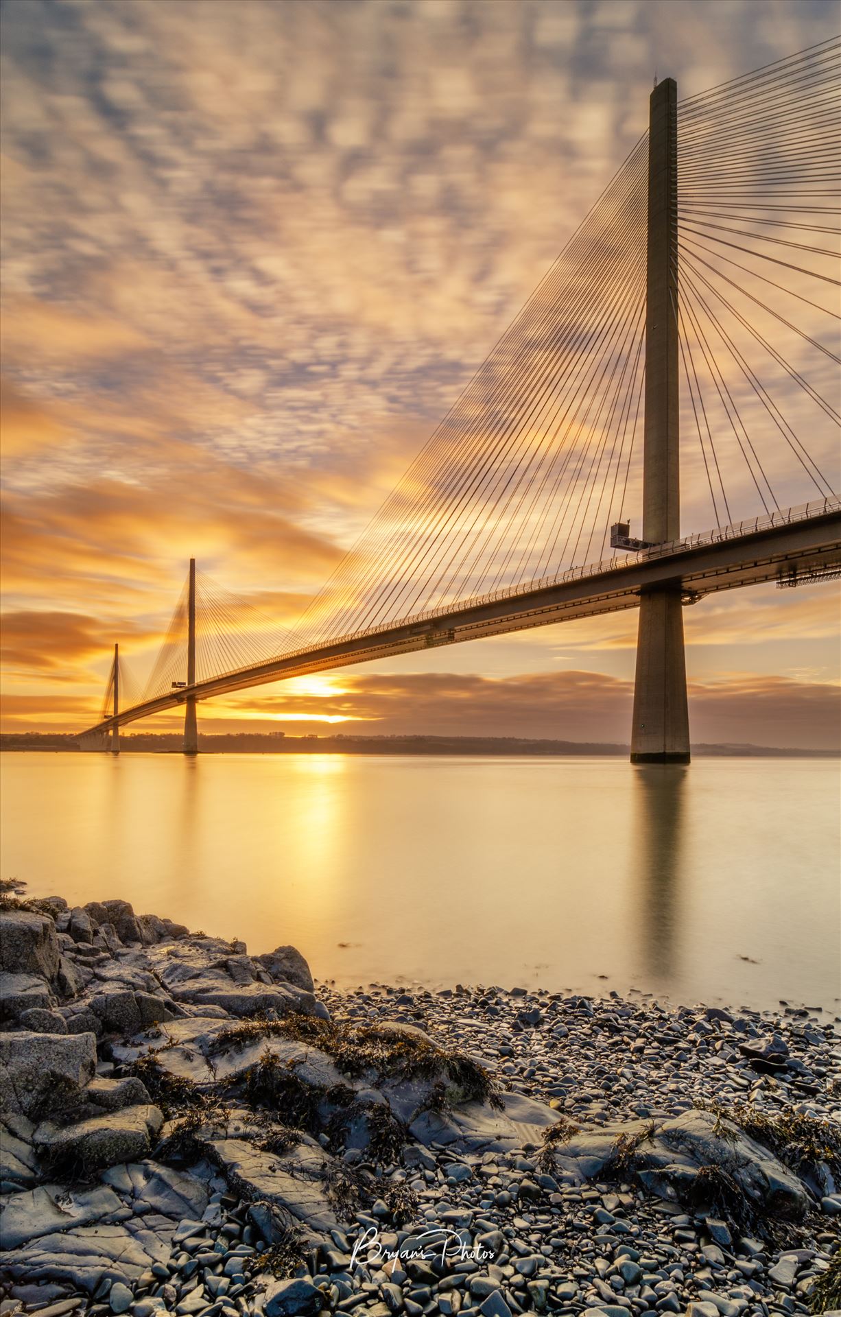 Queensferry Sunset Portrait - A portrait photograph of the Queensferry Crossing taken at sunset from North Queensferry on the Fife coast. by Bryans Photos