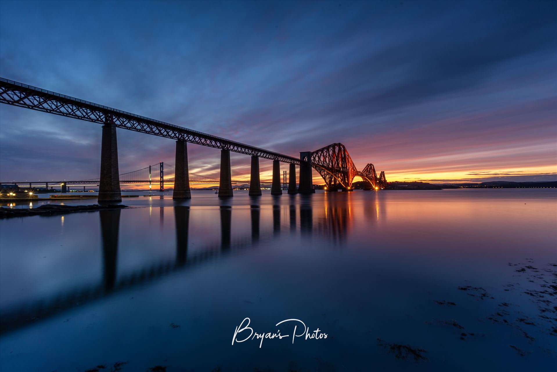 South Queensferry Sunset - A photograph of the Forth Rail Bridge taken at sunset from the banks of the river Forth at South Queensferry. by Bryans Photos