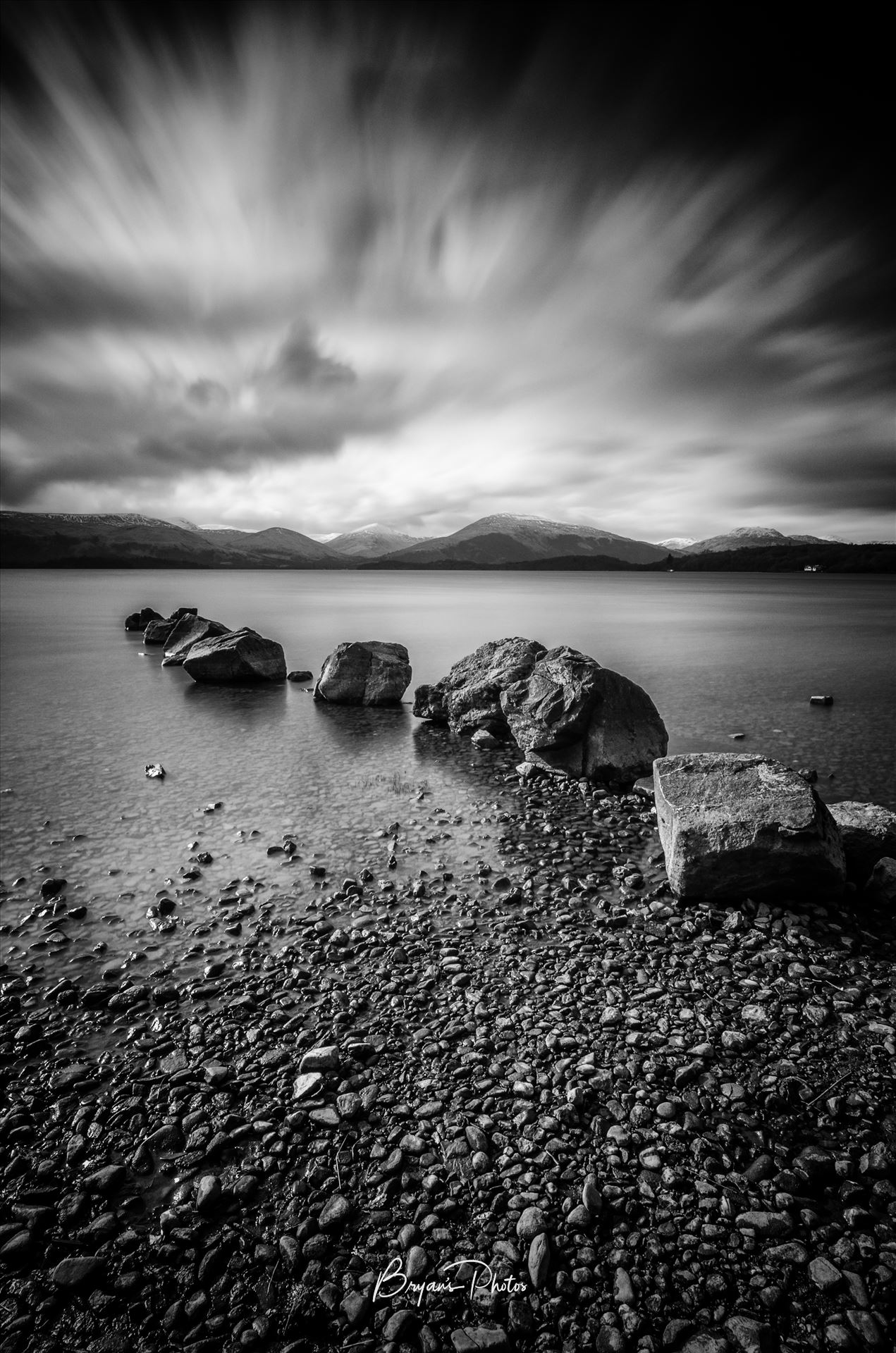 Milarrochy Bay - A black and white long exposure photograph of Loch Lomond taken from Milarrochy Bay. by Bryans Photos