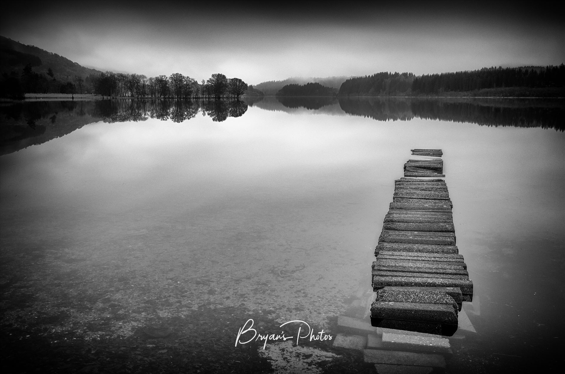 Loch Ard - A black and white photograph of an old jetty at Loch Ard taken from Kinlochard. by Bryans Photos