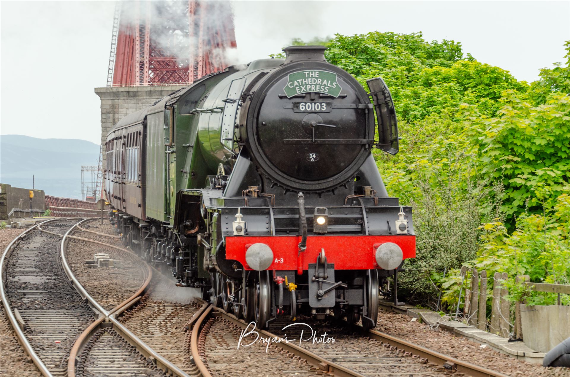 The Scotsman and the Bridge - A photograph of the iconic Flying Scotsman steam engine as it approaches North Queensferry station with the Forth Rail Bridge in the background. by Bryans Photos