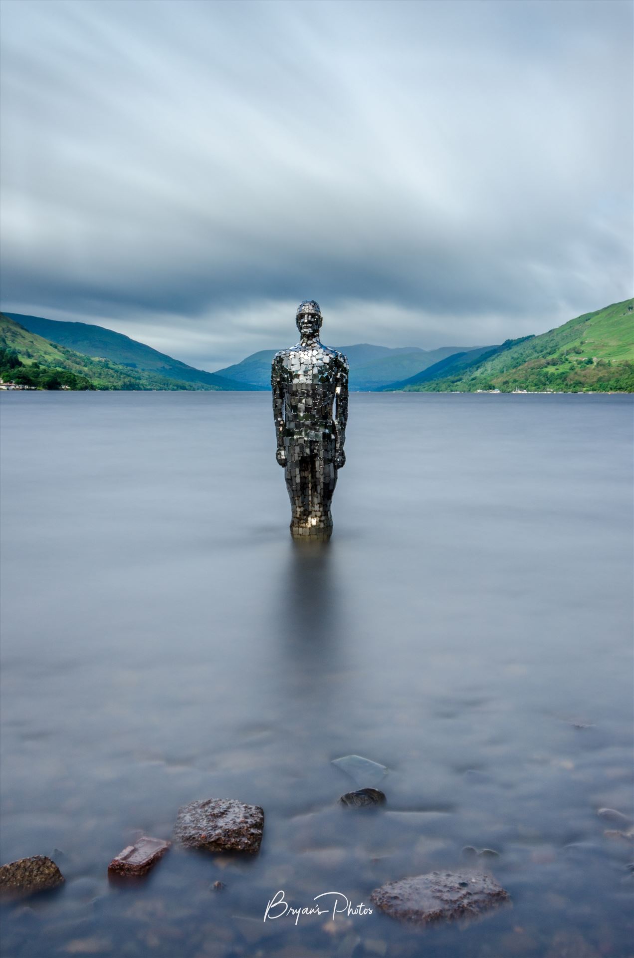 Still at Loch Earn - A long exposure photograph of the still mirror man sculpture taken from St Fillans at Loch Earn. by Bryans Photos