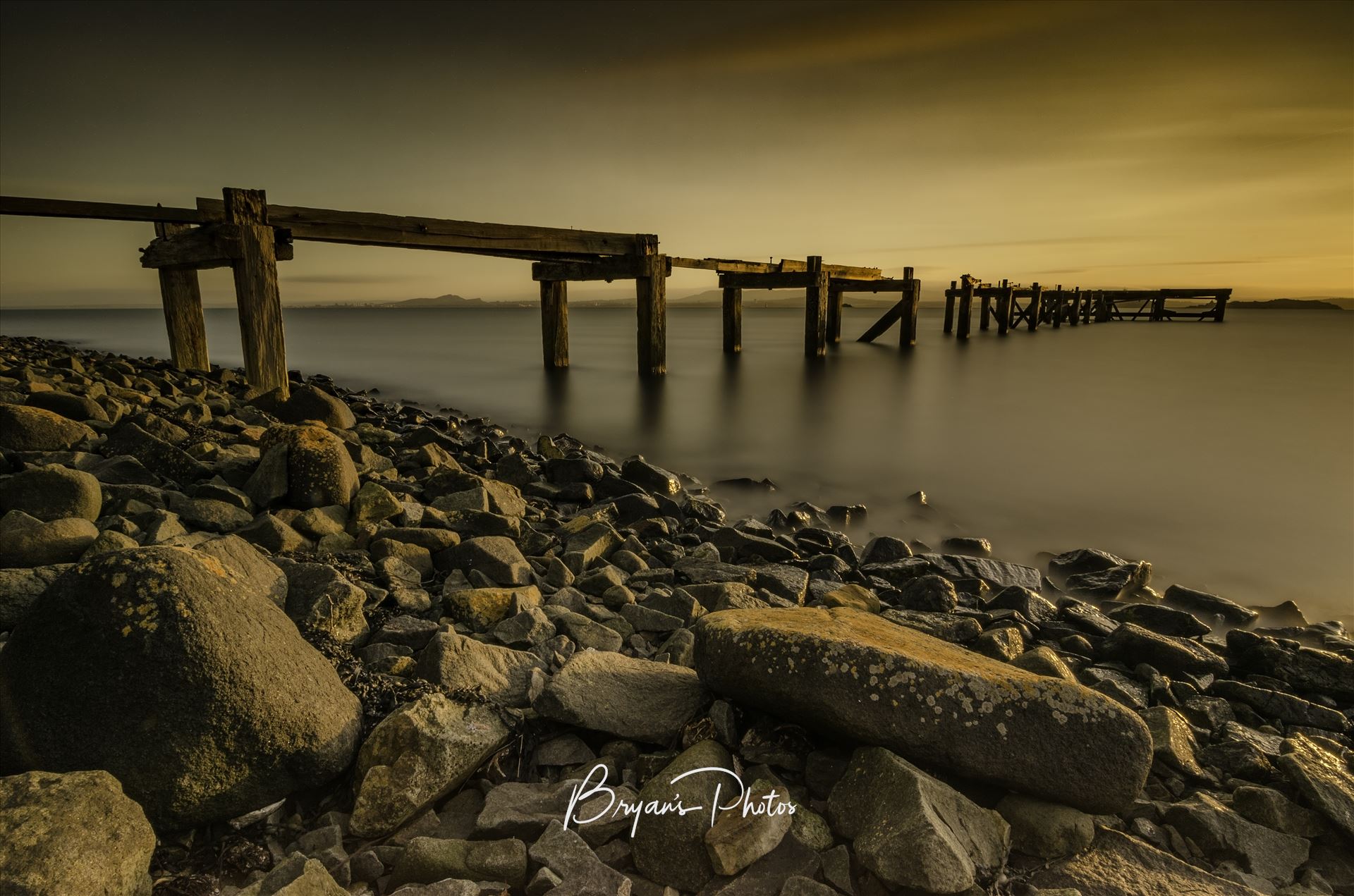 Hawkcraig Pier - A long exposure photograph of the abandoned  Hawkcraig pier at Aberdour taken at sunset. by Bryans Photos