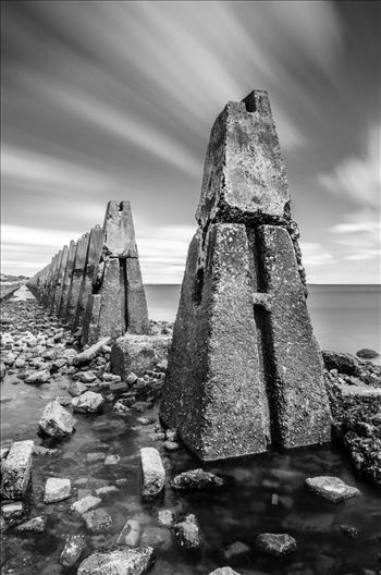 A black and white long exposure photograph of the causeway to Cramond Island.