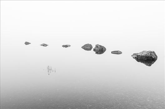 A long exposure photograph of the rocks at Milarrochy Bay Loch Lomond.