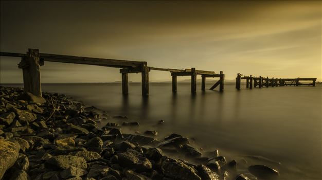 A long exposure photograph of the abandoned pier at Aberdour taken at sunset.