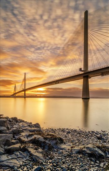 A portrait photograph of the Queensferry Crossing taken at sunset from North Queensferry on the Fife coast.