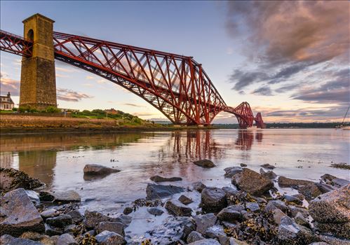 A colour photograph of the Forth Rail Bridge taken from North Queensferry at sunet.