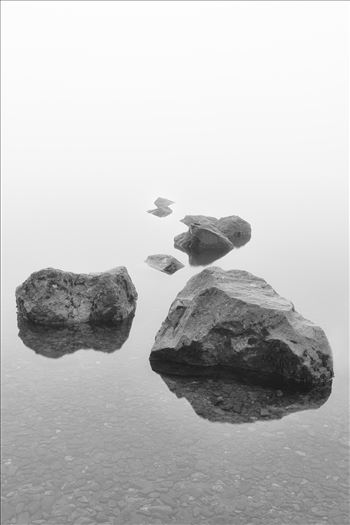 A black and white photograph of the rocks at Milarrochy Bay Loch Lomond.