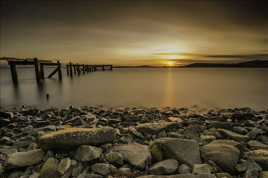 A long exposure photograph of the abandoned  Hawkcraig pier at Aberdour taken at sunset.